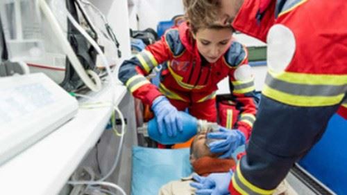 Two paramedics work on stabilizing a man.